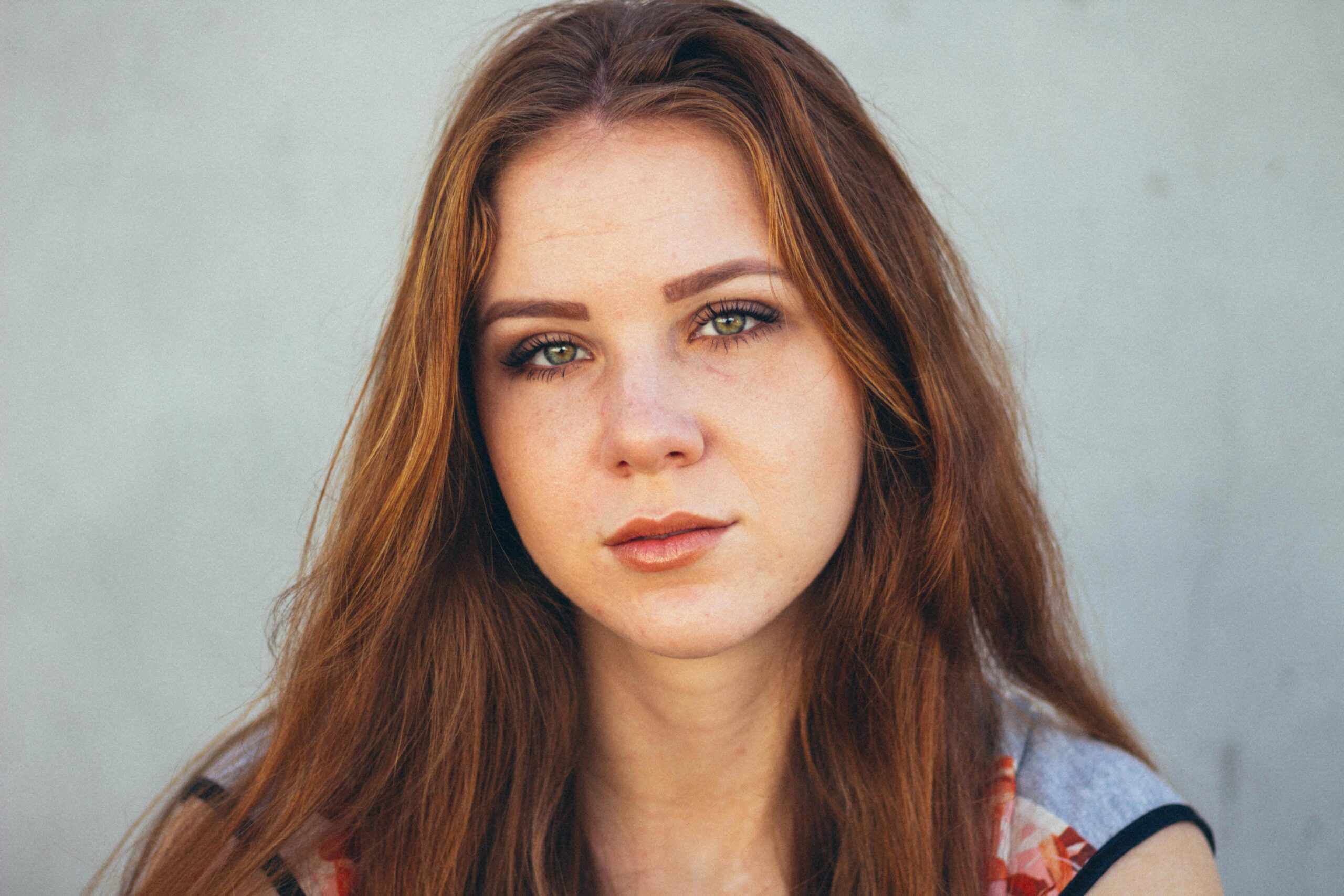 Stunning close-up portrait of a young woman with red hair and expressive eyes.